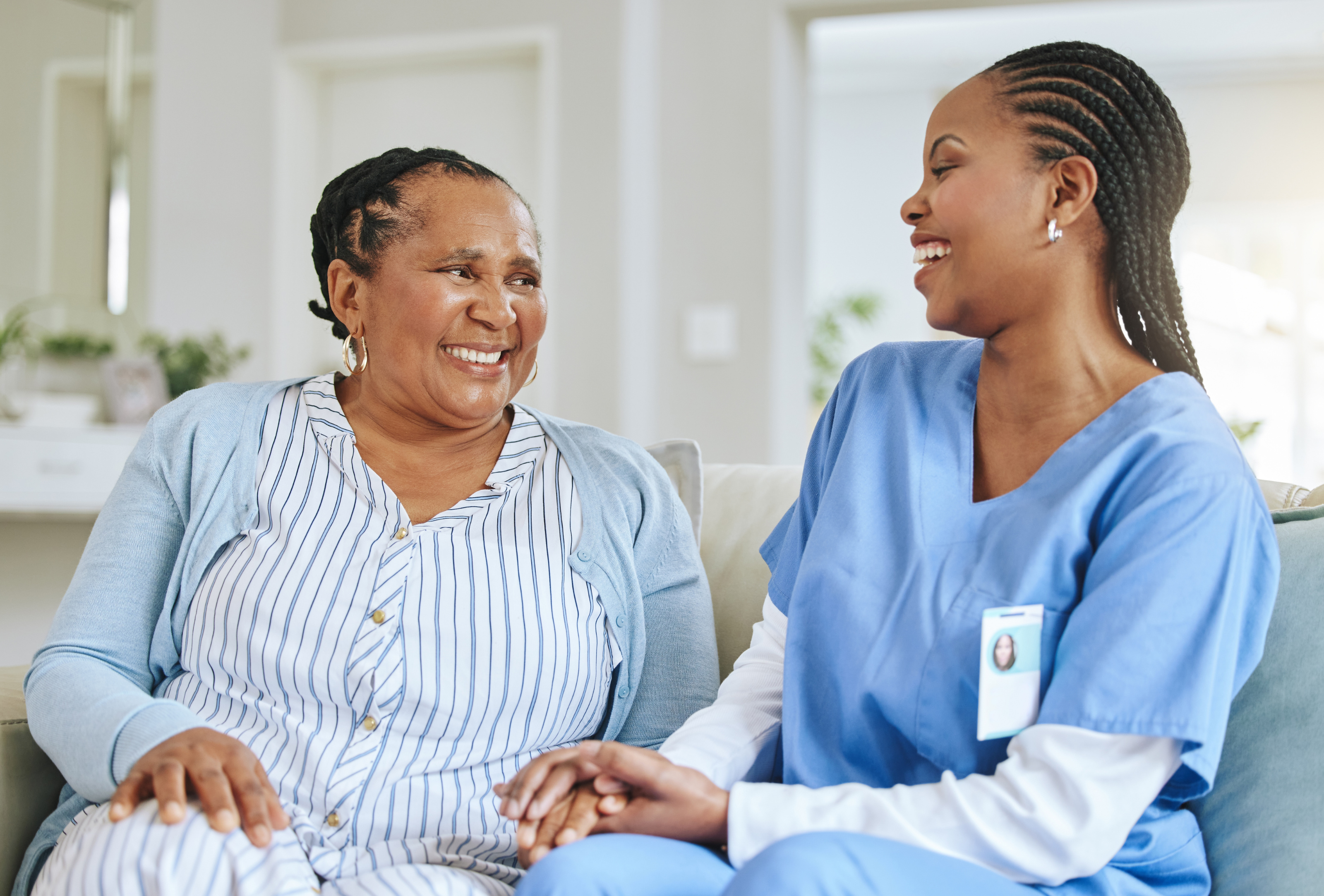Elderly woman with carer holding hands
