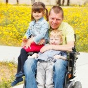 Disabled father in wheelchair with his two children