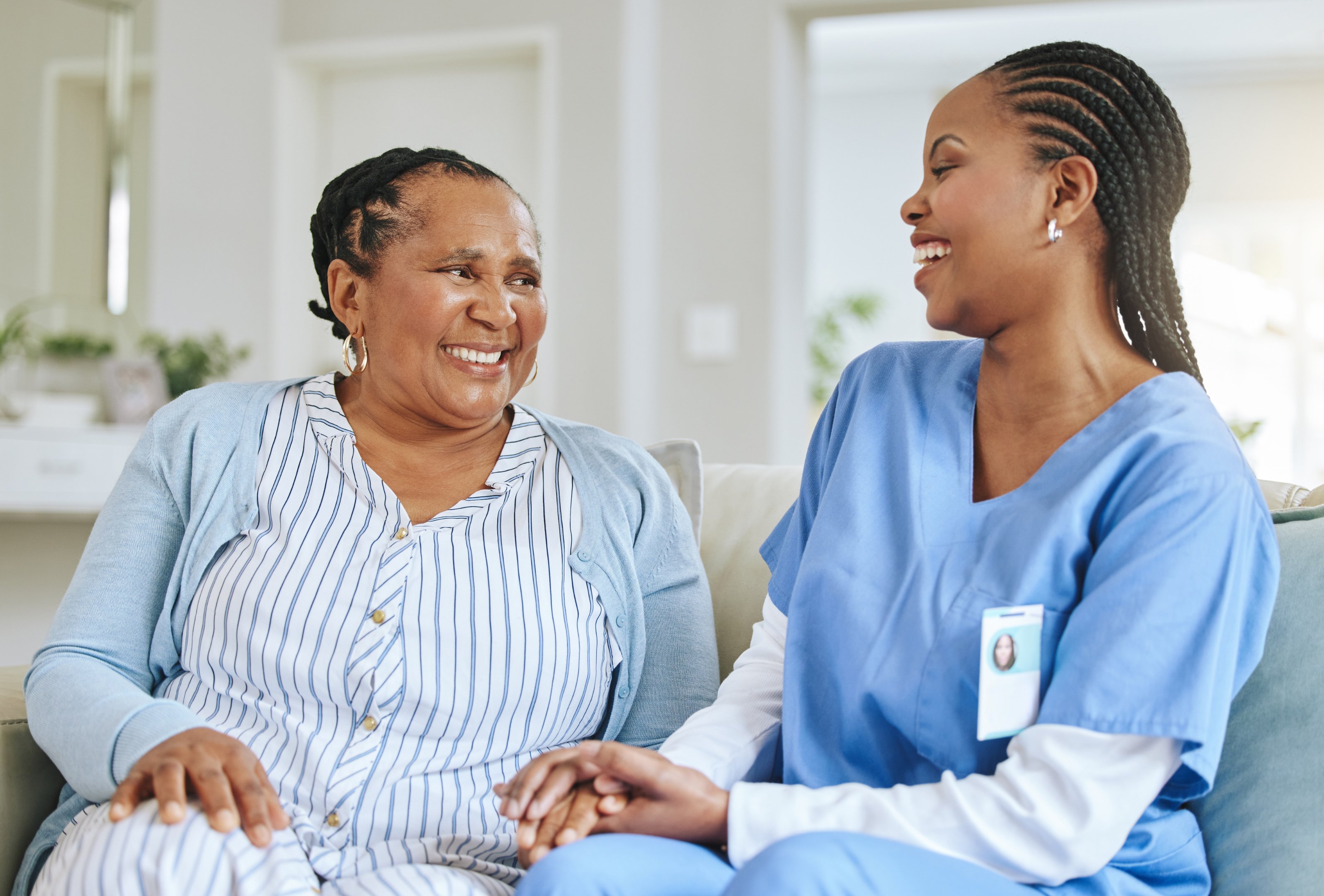 Elderly woman with carer holding hands