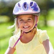 young girl wearing a cycle helmet on a bike